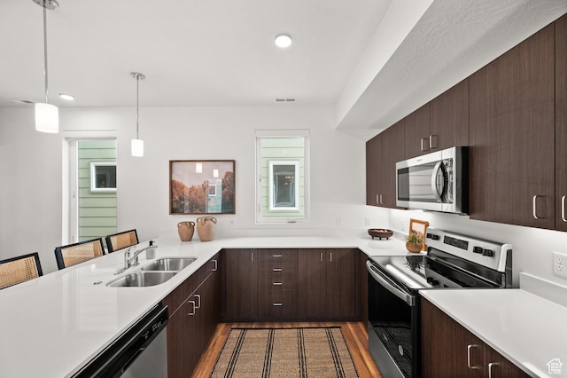 1034 W 1700 S Unit 121, Salt Lake City, UT 84104 - kitchen with stainless steel appliances, a sink, light countertops, dark brown cabinetry, and recessed lighting