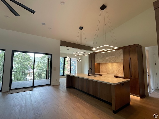 101 Crestview Cir, Park City, UT 84098 - kitchen featuring high vaulted ceiling, modern cabinets, a spacious island, light wood-style floors, and a sink