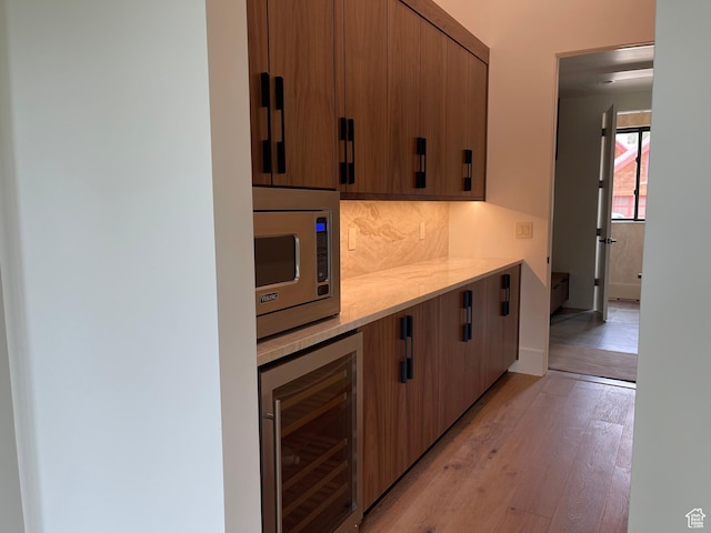 101 Crestview Cir, Park City, UT 84098 - kitchen featuring beverage cooler, stainless steel microwave, light countertops, light wood-style floors, and decorative backsplash