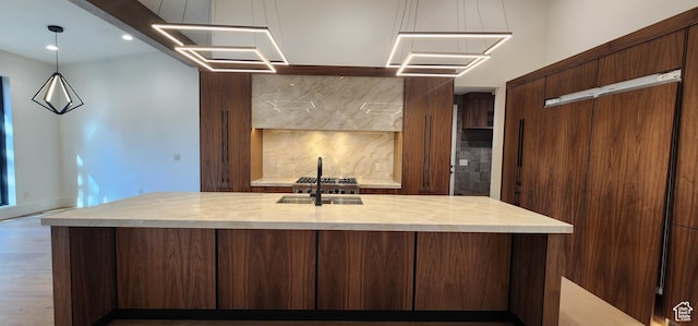 101 Crestview Cir, Park City, UT 84098 - kitchen featuring light countertops, a sink, tasteful backsplash, an island with sink, and wood finished floors