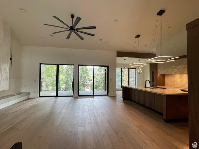 101 Crestview Cir, Park City, UT 84098 - unfurnished living room with a sink, light wood-type flooring, a ceiling fan, and a high ceiling