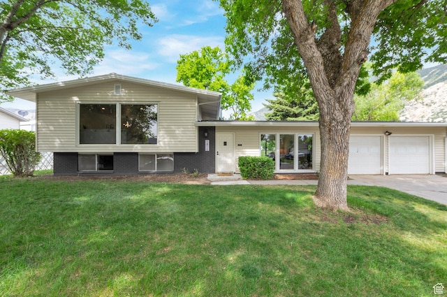1416 N Eyrie Dr E, Ogden, UT 84404 - split level home with an attached garage, concrete driveway, and a front yard