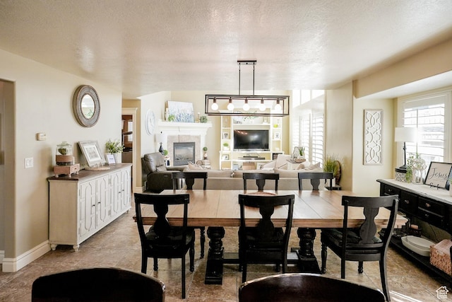 1901 S 1375 W, Syracuse, UT 84075 - dining space with plenty of natural light, a tile fireplace, a textured ceiling, and baseboards