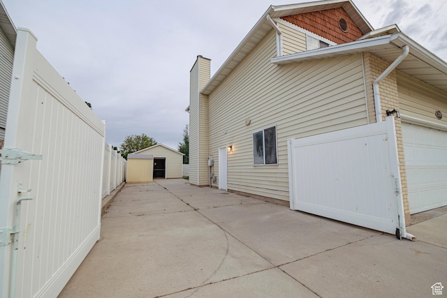 2979 W 4275 S, Roy, UT 84067 - view of side of property featuring a garage, driveway, and a chimney