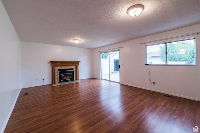 2979 W 4275 S, Roy, UT 84067 - unfurnished living room with a tile fireplace, wood finished floors, a textured ceiling, and baseboards