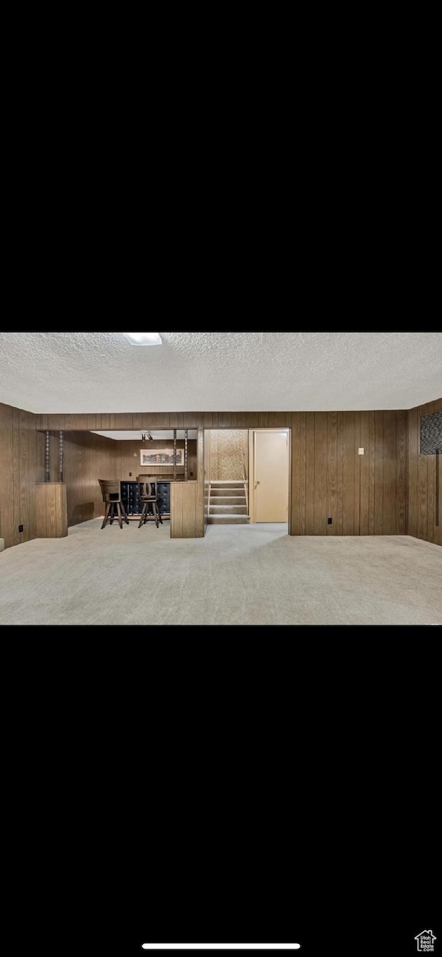 5540 S 850 E Unit 38, South Ogden, UT 84405 - finished below grade area with carpet, a textured ceiling, wooden walls, and stairs