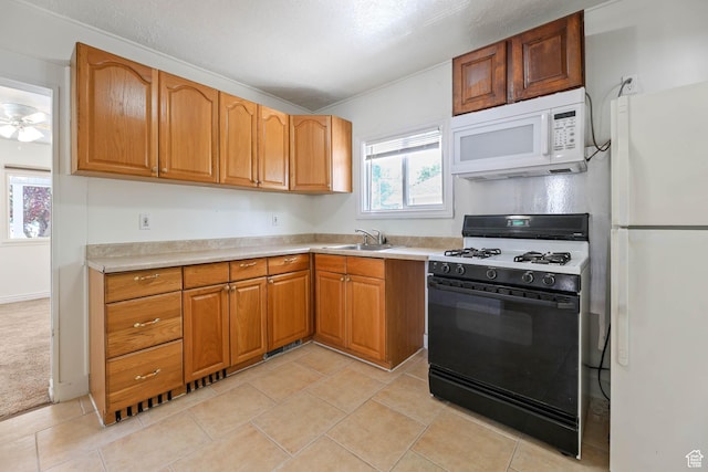 806 E Canyon Rd, Ogden, UT 84404 - kitchen with white appliances, a sink, light countertops, brown cabinets, and light tile patterned flooring