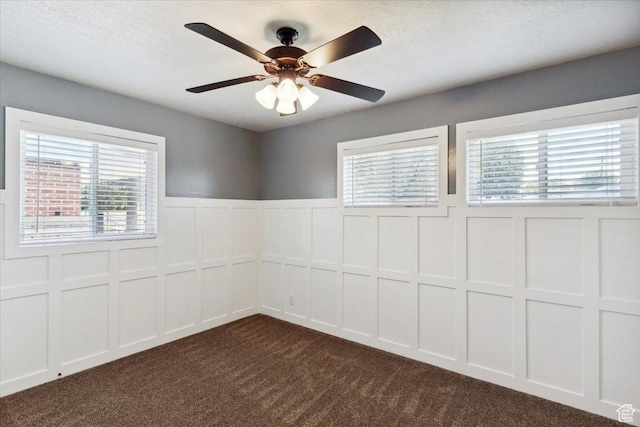 320 E 4600 S, Washington Terrace, UT 84405 - empty room with a decorative wall, dark colored carpet, plenty of natural light, wainscoting, and a ceiling fan