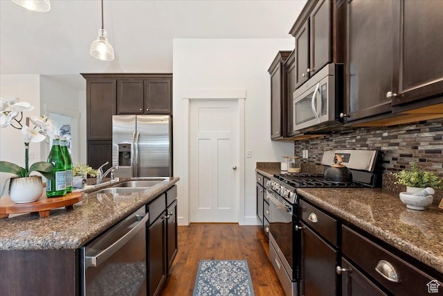 1918 W City Village Way Unit 140, Riverton, UT 84065 - kitchen with stainless steel appliances, a sink, dark brown cabinetry, decorative backsplash, and dark wood finished floors