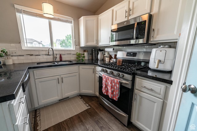 1542 N 2530 W, Clinton, UT 84015 - kitchen with stainless steel appliances, a sink, dark countertops, dark wood-type flooring, and white cabinetry