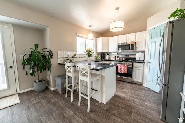 1542 N 2530 W, Clinton, UT 84015 - kitchen with appliances with stainless steel finishes, a peninsula, dark countertops, backsplash, and dark wood-style floors