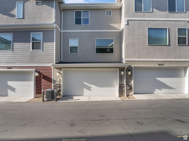 3671 W Sunrise Sky Ln Unit 1022, South Jordan, UT 84009 - view of front of property featuring stucco siding, an attached garage, cooling unit, and stone siding