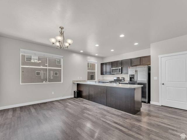 3671 W Sunrise Sky Ln Unit 1022, South Jordan, UT 84009 - kitchen featuring appliances with stainless steel finishes, a chandelier, dark wood-style flooring, a peninsula, and dark brown cabinetry