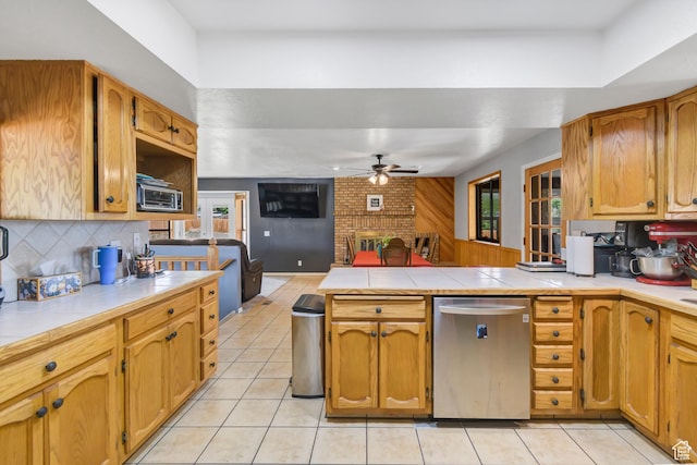155 S 200 W, Gunnison, UT 84634 - kitchen featuring dishwasher, ceiling fan, a brick fireplace, and light tile patterned floors