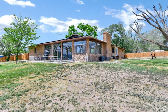 155 S 200 W, Gunnison, UT 84634 - back of property with a chimney, stone siding, and a sunroom