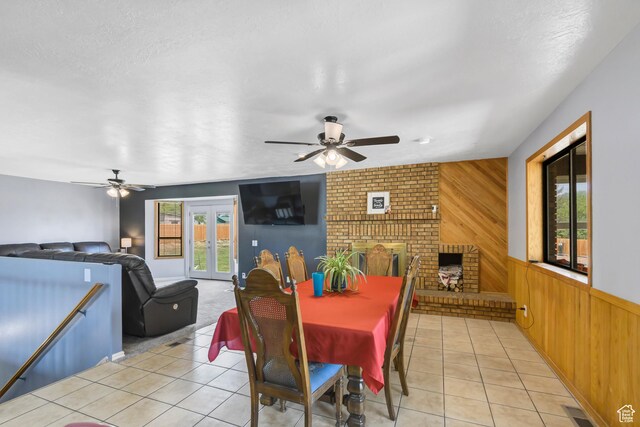 155 S 200 W, Gunnison, UT 84634 - dining space with ceiling fan, wooden walls, light tile patterned floors, and a brick fireplace