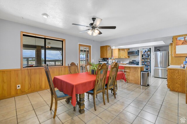 155 S 200 W, Gunnison, UT 84634 - dining area with wainscoting, wood walls, a ceiling fan, and light tile patterned flooring