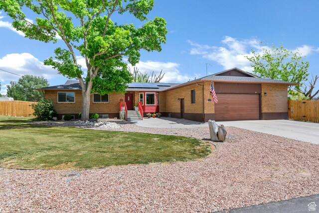 155 S 200 W, Gunnison, UT 84634 - ranch-style house with solar panels, an attached garage, brick siding, concrete driveway, and entry steps