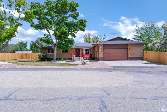 155 S 200 W, Gunnison, UT 84634 - single story home with brick siding, a garage, solar panels, and concrete driveway