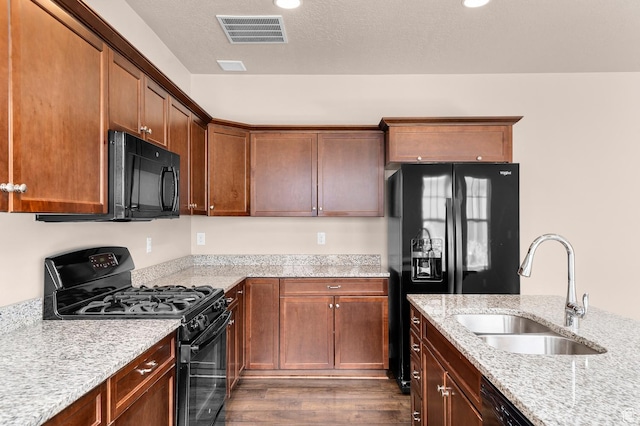 4908 W Duckhorn Dr, South Jordan, UT 84009 - kitchen featuring black appliances, a sink, dark wood-style floors, and light stone counters