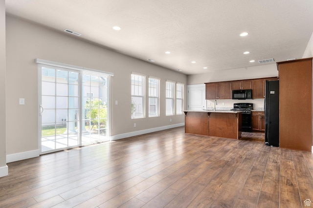 4908 W Duckhorn Dr, South Jordan, UT 84009 - kitchen featuring black appliances, recessed lighting, open floor plan, baseboards, and dark wood-type flooring