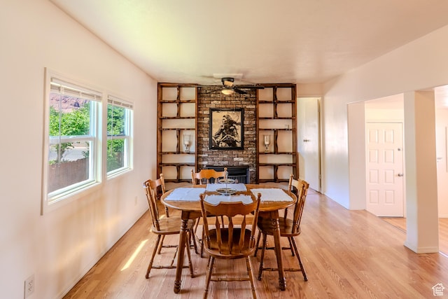 476 Cliffview Dr, Moab, UT 84532 - dining area with light wood-type flooring, a ceiling fan, a fireplace, built in shelves, and baseboards