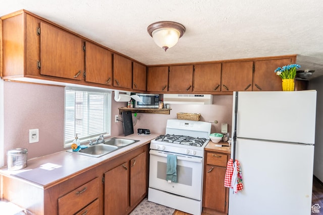 476 Cliffview Dr, Moab, UT 84532 - kitchen featuring white appliances, under cabinet range hood, a sink, light countertops, and brown cabinetry