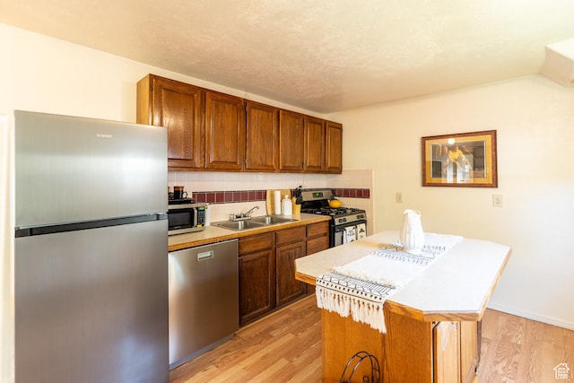 476 Cliffview Dr, Moab, UT 84532 - kitchen with appliances with stainless steel finishes, a sink, light wood finished floors, a kitchen island, and light countertops