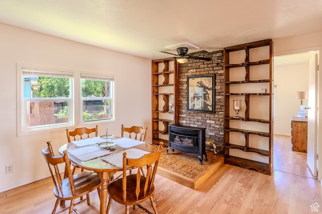 476 Cliffview Dr, Moab, UT 84532 - dining area featuring a wood stove, light wood-type flooring, a ceiling fan, and built in shelves