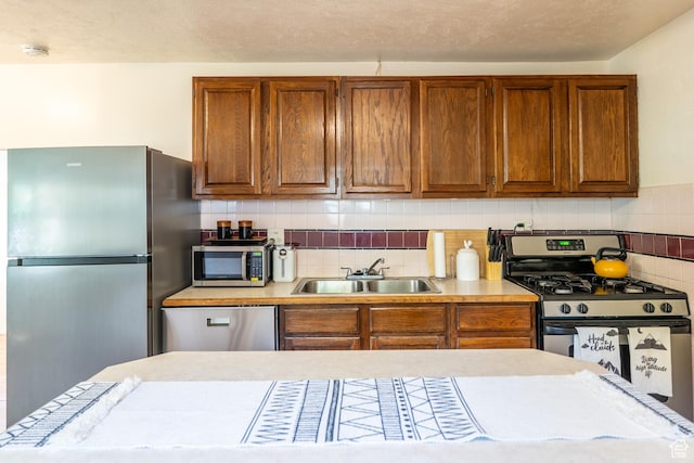 476 Cliffview Dr, Moab, UT 84532 - kitchen featuring appliances with stainless steel finishes, a sink, light countertops, and brown cabinetry
