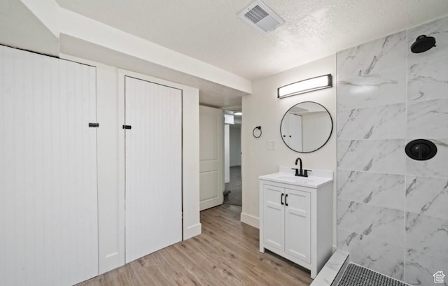 133 Country Club Dr, South Ogden, UT 84405 - bathroom with a tile shower, vanity, wood finished floors, and a textured ceiling