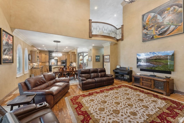 13302 S Corner Wood Dr E, Draper, UT 84020 - living area with a towering ceiling, light wood finished floors, crown molding, plenty of natural light, and baseboards