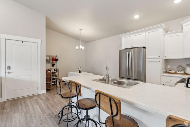 1128 S 820 E Unit 3301, Heber City, UT 84032 - kitchen featuring freestanding refrigerator, a sink, light wood-style flooring, a kitchen breakfast bar, and white cabinets