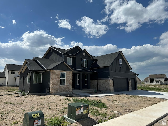 325 N 1040 E Unit 26, Salem, UT 84653 - view of front of house with board and batten siding, an attached garage, driveway, stone siding, and covered porch