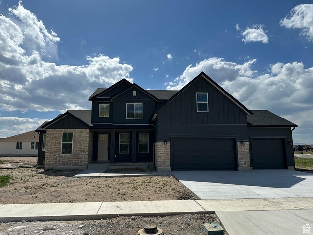 325 N 1040 E Unit 26, Salem, UT 84653 - view of front facade featuring board and batten siding, concrete driveway, a garage, stone siding, and an attached garage