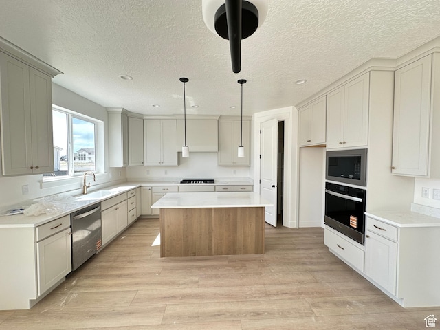 325 N 1040 E Unit 26, Salem, UT 84653 - kitchen featuring stainless steel appliances, a sink, a center island, light wood-style flooring, and pendant lighting