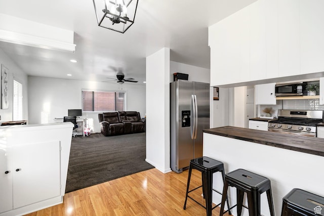 345 W 300 N, Richfield, UT 84701 - kitchen featuring stainless steel appliances, butcher block countertops, a breakfast bar, white cabinetry, and a ceiling fan