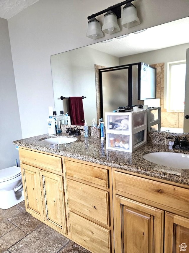 3788 S 410 W, Vernal, UT 84078 - bathroom featuring double vanity, toilet, stone finish flooring, and a shower with shower door