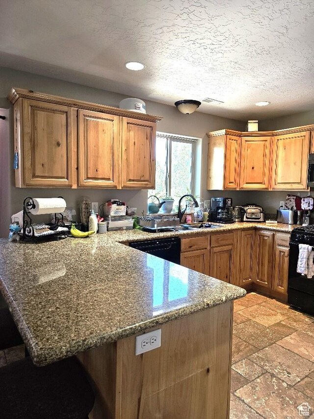 3788 S 410 W, Vernal, UT 84078 - kitchen featuring black appliances, a peninsula, recessed lighting, light stone counters, and a breakfast bar