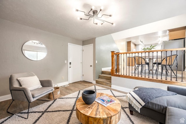 10297 S Weeping Willow Dr E, Sandy, UT 84070 - living area with wood finished floors, baseboards, a chandelier, and stairs