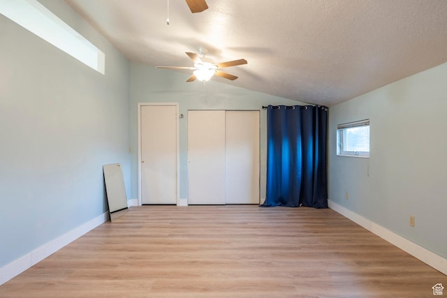 10297 S Weeping Willow Dr E, Sandy, UT 84070 - unfurnished bedroom with lofted ceiling, light wood-style flooring, a ceiling fan, a textured ceiling, and baseboards