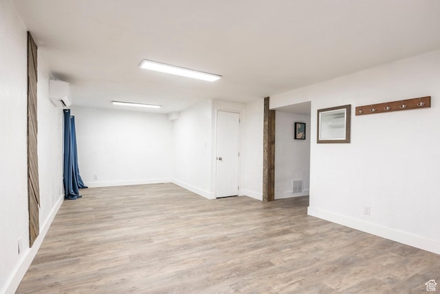 10297 S Weeping Willow Dr E, Sandy, UT 84070 - spare room featuring a wall unit AC, light wood finished floors, and baseboards