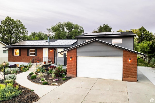 10297 S Weeping Willow Dr E, Sandy, UT 84070 - view of front of house featuring brick siding, solar panels, a garage, and concrete driveway