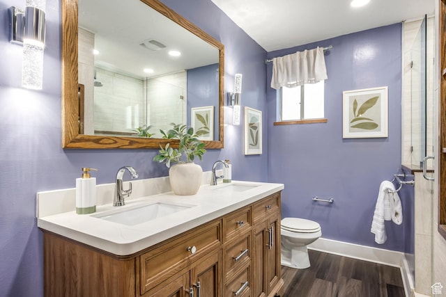 10297 S Weeping Willow Dr E, Sandy, UT 84070 - bathroom featuring baseboards, a shower stall, wood finished floors, toilet, and double vanity