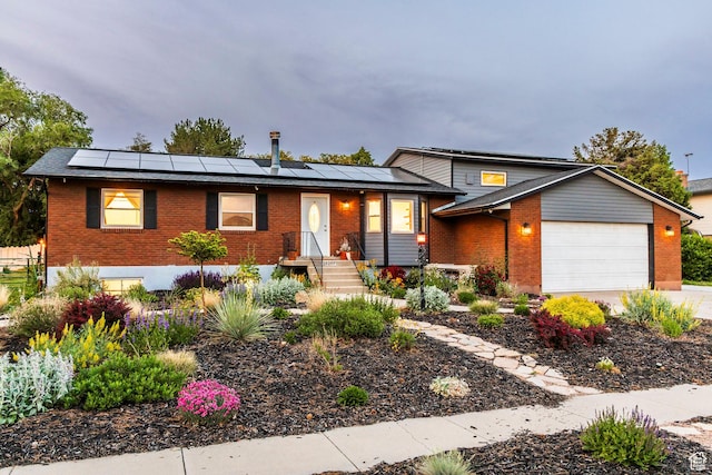 10297 S Weeping Willow Dr E, Sandy, UT 84070 - view of front of property with brick siding, a garage, solar panels, and driveway