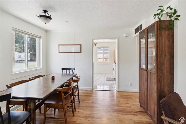 1142 W Fremont Ave, Salt Lake City, UT 84104 - dining area featuring a textured ceiling, light wood-type flooring, and baseboards