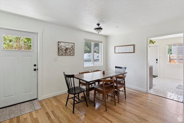 1142 W Fremont Ave, Salt Lake City, UT 84104 - dining area featuring healthy amount of natural light, light wood-style flooring, a textured ceiling, and baseboards