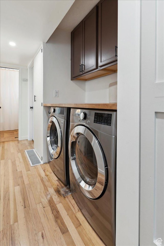 1142 W Fremont Ave, Salt Lake City, UT 84104 - washroom with cabinet space, washer and clothes dryer, and light wood-style floors