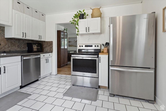 1142 W Fremont Ave, Salt Lake City, UT 84104 - kitchen featuring stainless steel appliances, white cabinetry, backsplash, and dark countertops