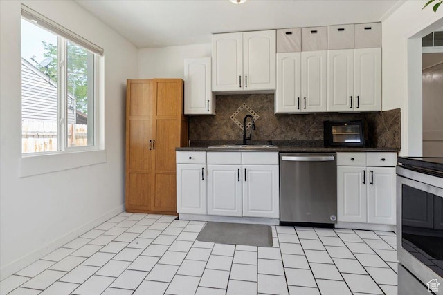 1142 W Fremont Ave, Salt Lake City, UT 84104 - kitchen featuring stainless steel appliances, a sink, tasteful backsplash, white cabinets, and baseboards